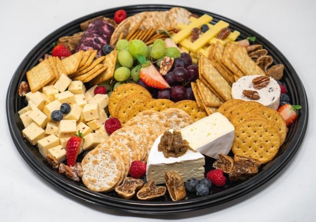 An artisanal cheese platter with crackers and fruit
