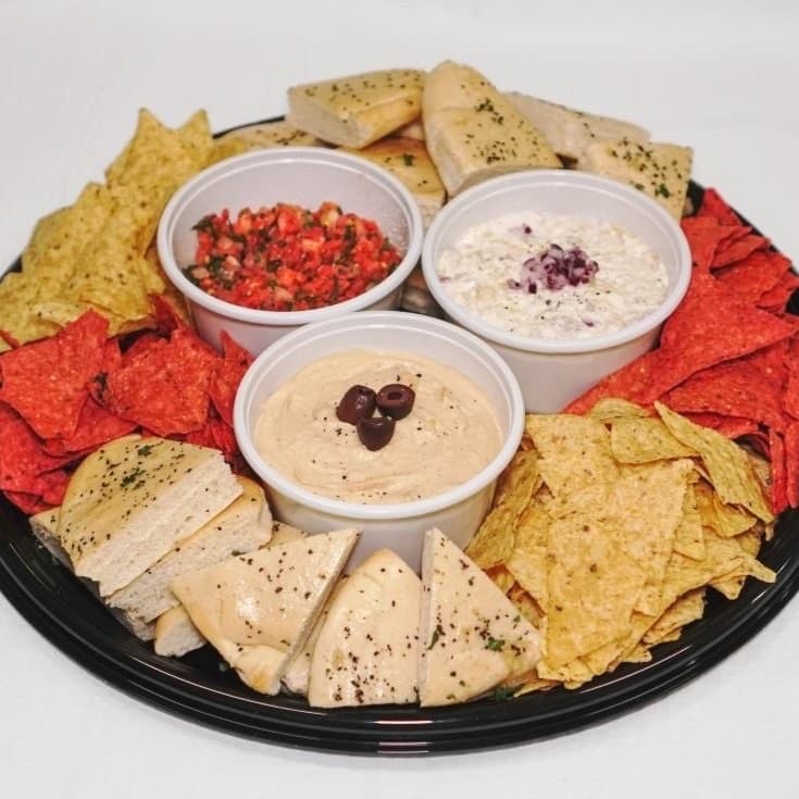 A trio of dip platter with tortilla chips and pita